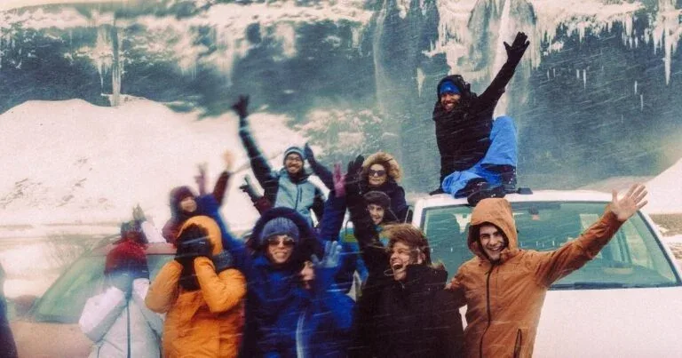 Grupo sorrindo com montanhas ao fundo na Islândia